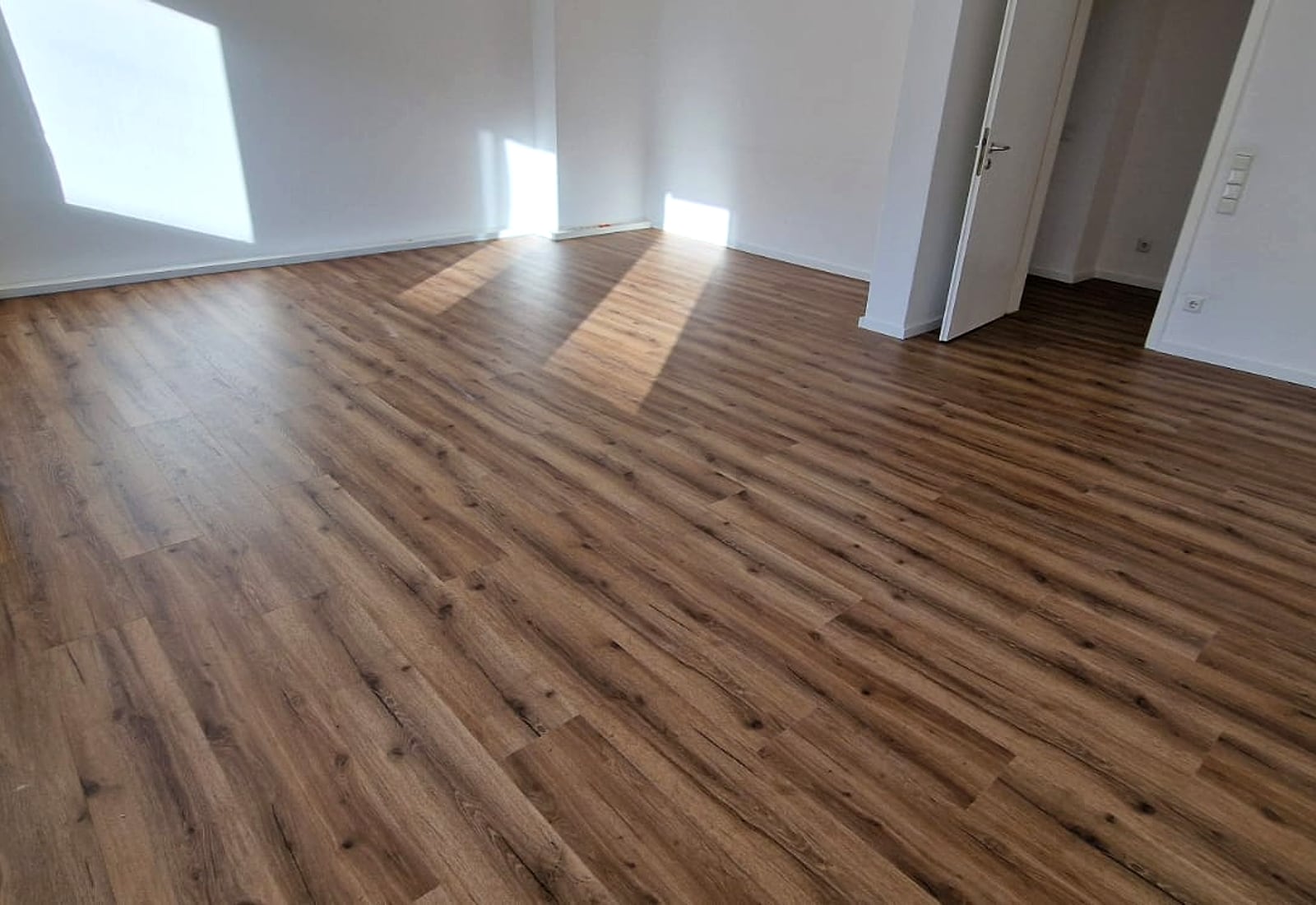 Frisch verlegter Holzoptikboden in einem hellen Wohnraum