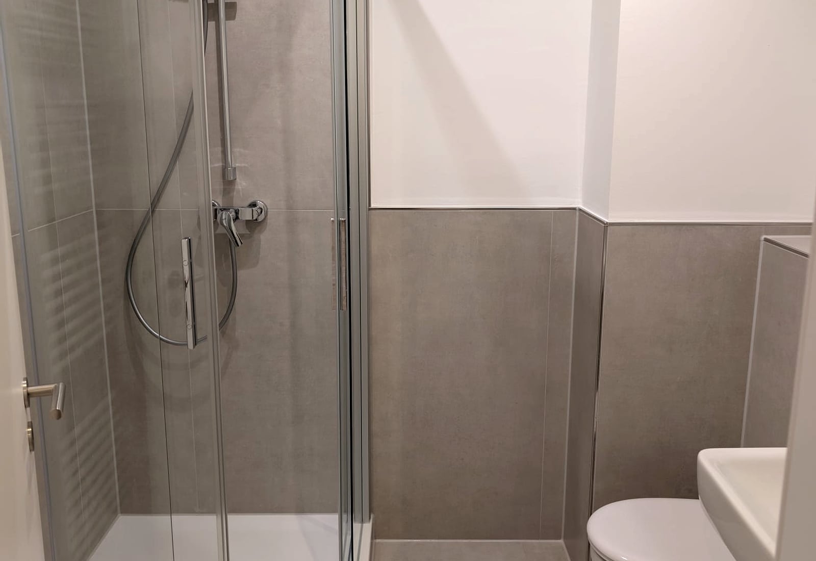 Modern gefliestes Bad mit Dusche und grauen Wandfliesen