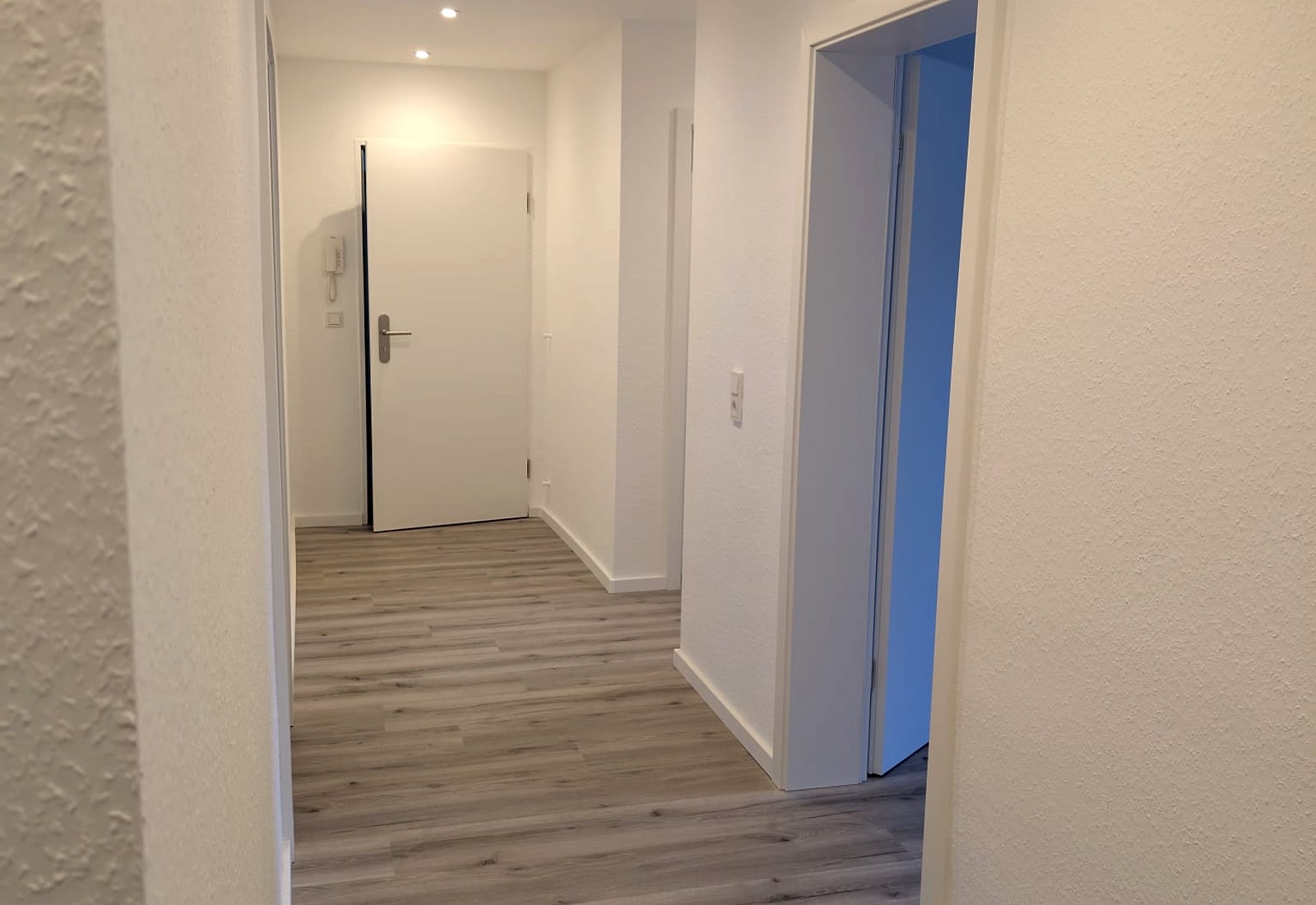 Renovierter Flur mit hellen Wänden und neuem Boden