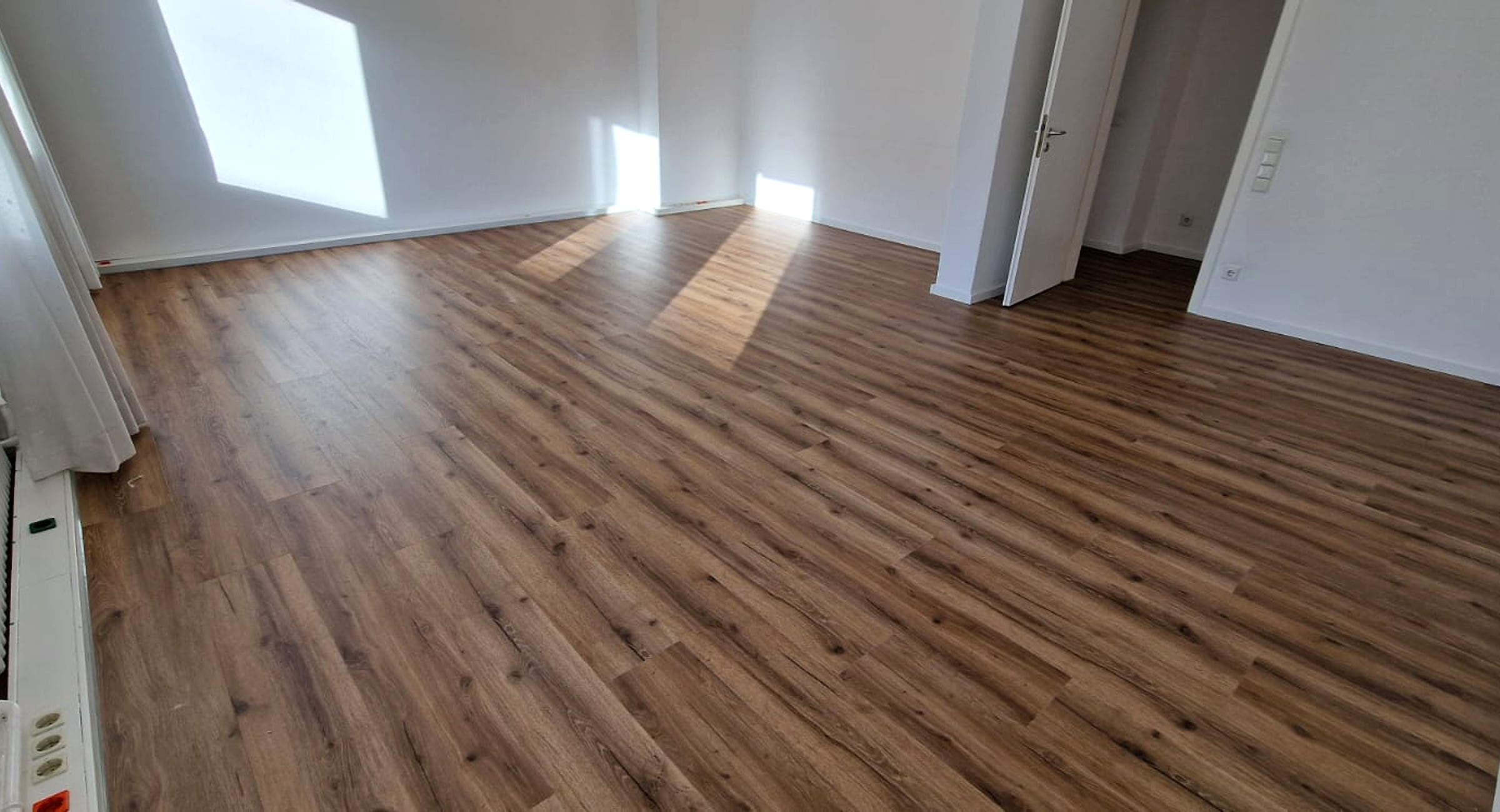Renovierter Wohnraum mit frisch verlegtem Boden