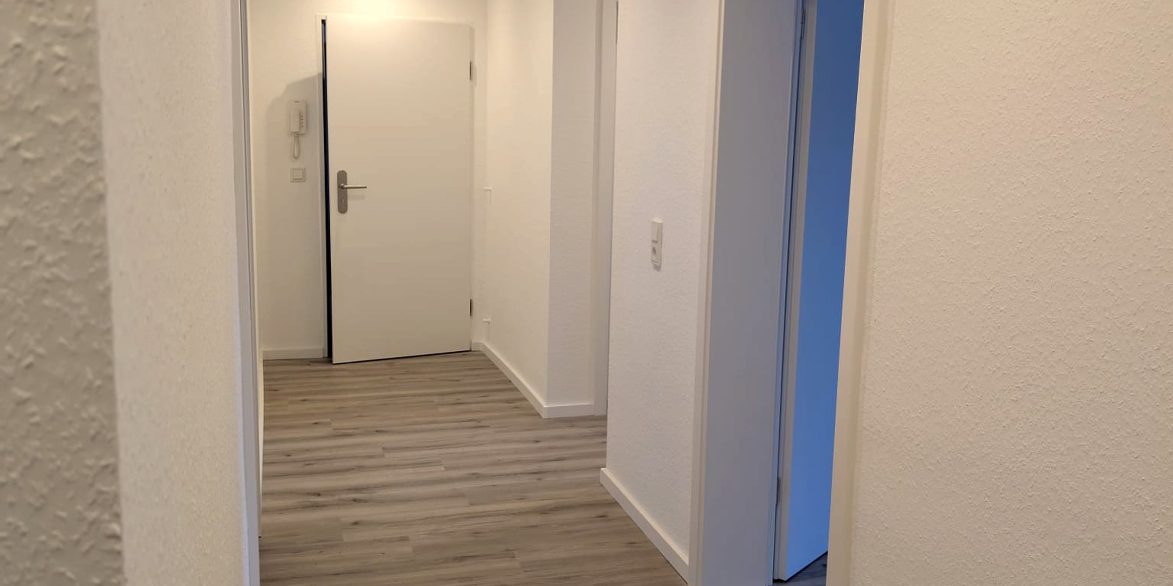 Renovierter Flur mit hellem Wandfinish und neuem Boden